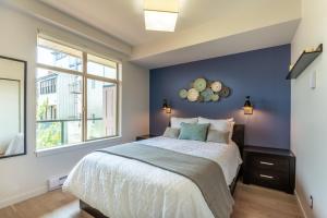 a bedroom with a large bed with a blue wall at Sun-Drenched Sophistication in Victoria