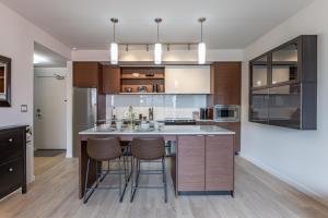 a kitchen with a large island with bar stools at Sun-Drenched Sophistication in Victoria