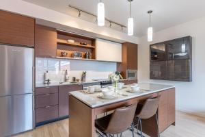 a kitchen with a large island with bar stools at Sun-Drenched Sophistication in Victoria +9 photos