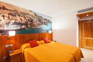 a bedroom with a yellow bed with a painting on the wall at Plaça De La Font in Tarragona