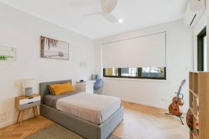 a bedroom with a bed and a guitar in it at Serenity at Salt - Beachside Beauty by uHoliday in Kingscliff +9 photos