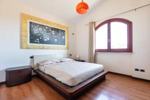 una camera da letto con un letto e una finestra di Villa Margot-Garden & Whirpool -5 Min to the beach a Quartu SantʼElena