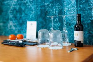 a bottle of wine and glasses on a wooden table at Hotel Auberge Nassau in Eindhoven