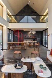 an open living room with tables and chairs at Scarlatta in Ghoti Budrukh