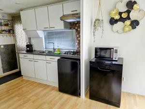 a kitchen with a black refrigerator and a microwave at Chalet V31 in Makkum