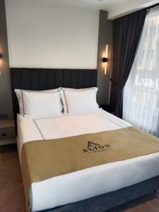 een slaapkamer met een groot bed met witte kussens bij Alion Hotel in Konak