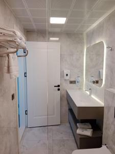 een badkamer met een douche, een wastafel en een spiegel bij Alion Hotel in Konak +122 foto's
