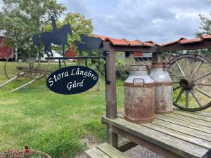 un cartello per un giardino con due vecchi barattoli di latte di Magasinet Stora Långbro a Tystberga