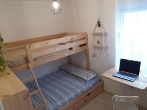 Un dormitorio con una litera y una computadora portátil en un escritorio. en Bungalow con Patio y Terraza Solárium, en Torrevieja