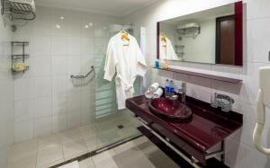 加利布港Casa Mare Resort - ex, Royal Tulip Beach Resort的带红色水槽和镜子的浴室