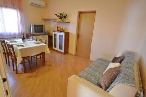 a living room with a table and a couch and a kitchen at Apartment Kuftic - Relax Zone - Quiet Street in Rovinj