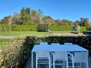 a white table with white chairs and a playground at Brooklyn Views - 4 Bedrooms in Feilding +13 photos