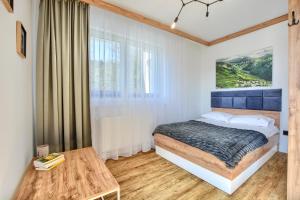 sypialnia z łóżkiem i stołem w obiekcie Westa Apartamenty w mieście Krynica Zdrój