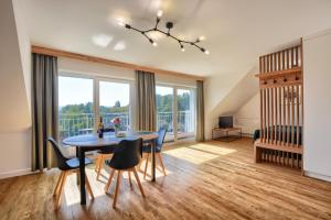salon ze stołem jadalnym i krzesłami w obiekcie Westa Apartamenty w mieście Krynica Zdrój