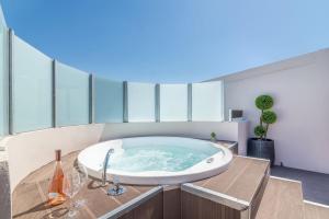 Cette chambre dispose d'une grande baignoire et de fenêtres. dans l'établissement Elegant Loft with Jacuzzi, à Ayía Marína 26 autres photos
