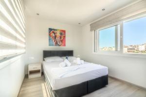 - une chambre blanche avec un grand lit et des fenêtres dans l'établissement Elegant Loft with Jacuzzi, à Ayía Marína