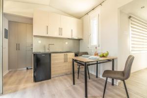 Il comprend une cuisine équipée d'une table et d'un réfrigérateur noir. dans l'établissement Elegant Loft with Jacuzzi, à Ayía Marína