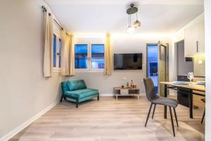 - un salon avec une table et une chaise verte dans l'établissement Elegant Loft with Jacuzzi, à Ayía Marína