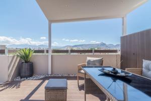 une terrasse avec une table et des chaises sur un balcon dans l'établissement Elegant Loft with Jacuzzi, à Ayía Marína