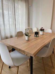 una mesa de comedor con sillas blancas alrededor en Lucus Urban Centre, en Lugo