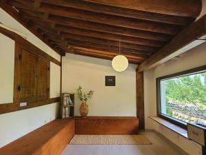a living room with a large window and wooden ceilings at Yeongam Haeden Hanok Stay in Yeongam