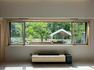 a large window in a room with a table at Gangchon 1225 Pension in Chuncheon
