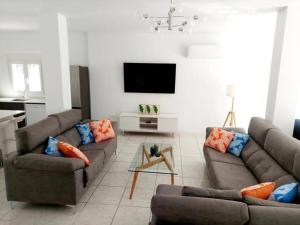 a living room with two couches and a tv at Casa Palma by Rental Hero in Los Alcázares +11 photos