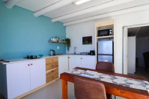 a kitchen with white cabinets and a wooden table at Dreamcatcher Lavender in Paternoster