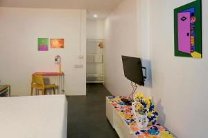 a room with a tv on a wall with a table at BW Thai Art Style Hotel in Bangkok