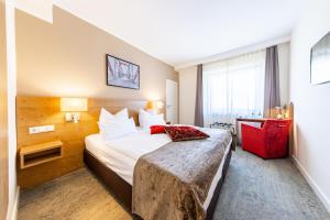 Cama ou camas em um quarto em Maingau Hotel