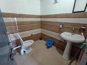 a bathroom with a toilet and a sink at HimWanderer Camps & Cottages Pangot in Nainital +101 photos