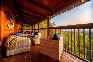 a porch with wicker chairs and a bed on a deck at Incredible Views l Family Friendly I Pool - Hot Tub in Sevierville