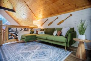 a man laying on a green couch in a living room at Incredible Views l Family Friendly I Pool - Hot Tub in Sevierville +81 photos