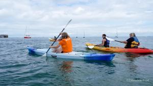 three people in kayaks in the ocean on the water at VVF Les Sableaux à Noirmoutier in Le Grand Vieil