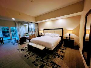 a bedroom with a large bed and a living room at Doral Pool 310 by WaveProperties in Miami