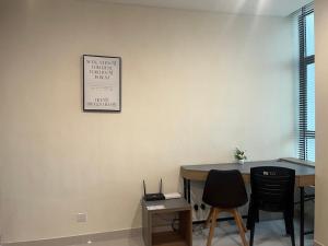 een kamer met een tafel en stoelen en een bord aan de muur bij Yenbear Homestay Kozi Square Kuching Sarawak in Kuching +15 foto's