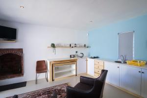 a kitchen with a table and chairs and a fireplace at Dreamcatcher Rosemary in Paternoster