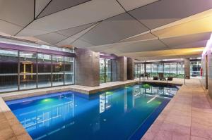 a swimming pool in a building with blue water at WOW Apartment on Spencer in Melbourne