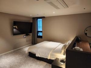 a bedroom with a large bed and a television at Queentown hotel in Goyang
