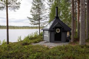 a black dog house next to a body of water at Villa Latvus in Rovaniemi