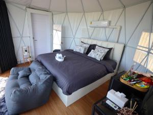 a bedroom with a large bed and a couch at Fulfield Cafe&Resort in Ban Wang Wa (1)