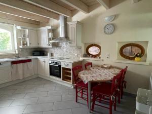 a kitchen with a table and a clock on the wall at TULIPES Et CETERA in Waldighofen