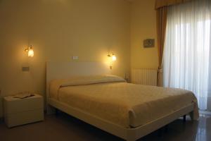 een slaapkamer met een groot bed en een raam bij Hotel Solaris in Giulianova