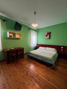 a bedroom with green walls and a bed and a desk at Corte Bussari in Arquà Polesine +49 photos