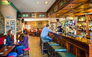 un grupo de personas sentadas en un bar en Dan Linehans Bar and B&B, en Killarney