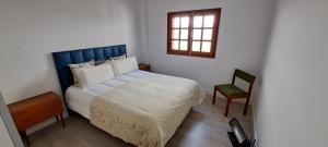a bedroom with a bed with a blue headboard and a chair at VILLA La TOSCA in Vega de San Mateo