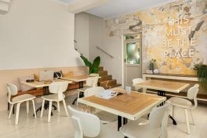 un restaurant avec des tables en bois et des chaises blanches dans l'établissement Neighbourgood Romney, au Cap