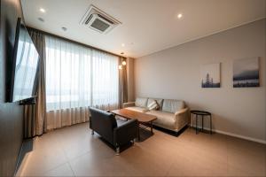 a living room with a couch and a table at Queentown hotel in Goyang