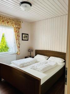 ハーレンにあるFerienhaus Bungalow Schloss Dankern, Emslandの窓のある大きなベッドのある寝室