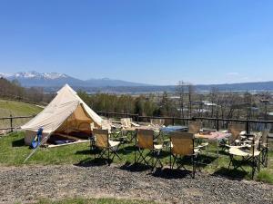 a group of chairs and a tent on a hill at The Kokage in Nakafurano
